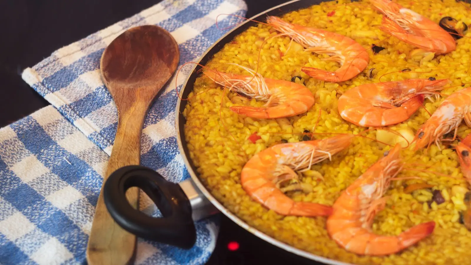 Mesa de restaurante con paella y vistas al mar en Orihuela Costa